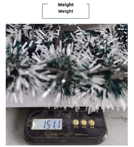 Detailed view of green and white Christmas tinsel wreath being weighed on a scale