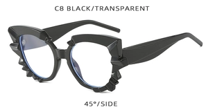 Detail view of avant-garde black cat-eye frame sunglasses with unique serrated edges