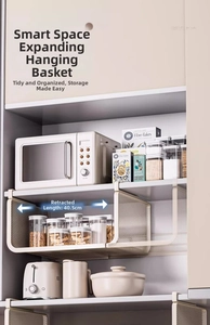Detailed view of white metal retractable under-shelf basket mounted in a kitchen cabinet