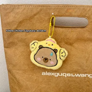 Plüsch-Capybara Anhänger im gelben Küken-Outfit an einer Tasche, Größe 8x10cm