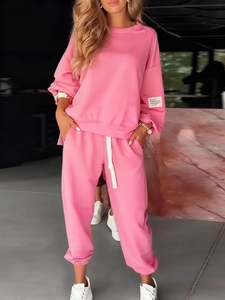 Detail of pink knitted two-piece set featuring long-sleeve top and wide-leg pocket pants