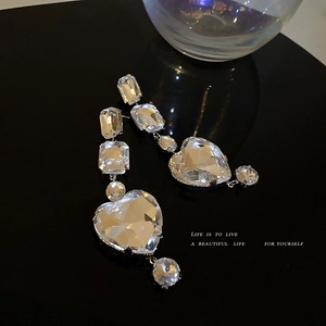 Elegant silver-toned heart-shaped drop earrings with brilliant-cut crystals on black background