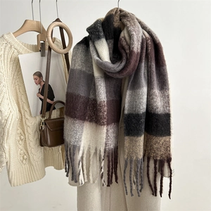 Detail of plaid mohair scarf with tassels paired with a wool coat and leather handbag