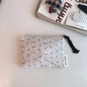 Floral cotton pouch detail showing simple wish label and black tassel zipper puller