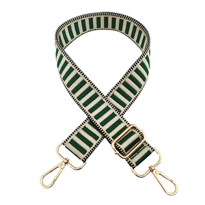 Detail of adjustable green and beige striped fabric strap with gold metal hooks