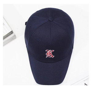 Detailed macro view of navy blue cotton baseball cap with 3D embroidered letter K logo