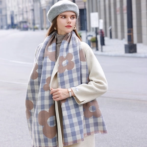 Plaid tassel scarf with floral patterns in blue and beige worn by a model in street view