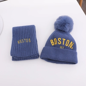 Detailansicht des blauen Strickmützen- und Schal-Sets mit Boston-Stickerei und Bommel