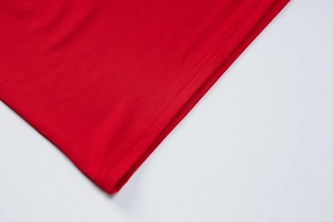 Close-up of red knitted fabric showing high-quality double-needle stitching detail