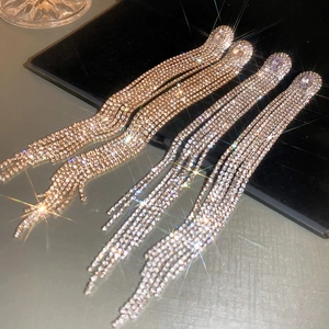Macro view of luxury long tassel earrings with sparkling rhinestones in gold and silver