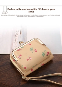 Detail of beige wallet with cherry print and golden clasp on a dark wooden table