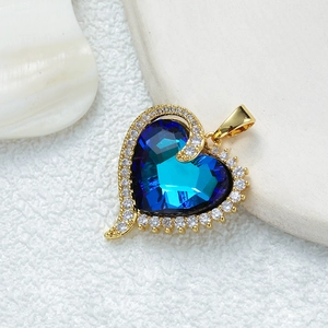 Collier cœur doré avec pierre bleu foncé et halo en zircon sur fond texturé blanc