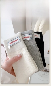 Detailed knit texture and stitched brand label on ribbed mid-calf cotton socks