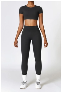 Détail de l'ensemble de yoga noir avec haut court à manches courtes et legging taille haute
