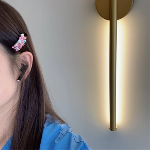 Gros plan d'une barrette à cheveux en strass rose et d'un appareil intra-auriculaire