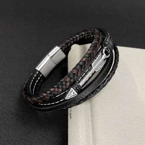 Macro shot of multi-layer leather braided bracelet with a metal arrow pendant detail