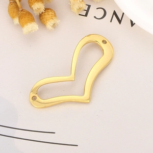 Détail macro du pendentif cœur évidé en acier doré avec deux trous de connexion