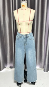 Détail d'un jean taille haute à jambes larges avec délavage bleu clair et ourlet effiloché