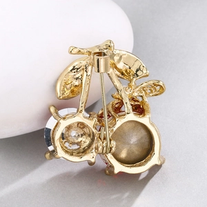 Detail of cherry brooch back showing secure pin clasp mechanism and gold alloy base