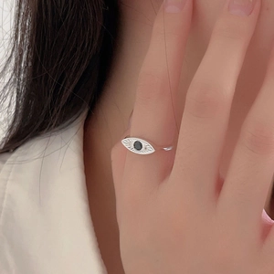 Minimalist 925 sterling silver eye-shaped ring with a black stone on model's finger