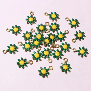 Scattered view of small golden daisy charms with green petals and yellow cores for DIY