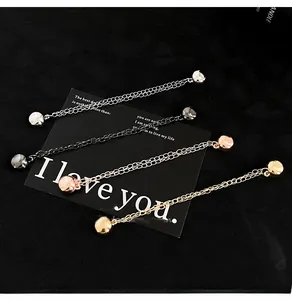 Close-up of four-color metal chains with polished beads for garment length adjustment