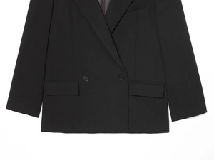 Flat lay of a black double-breasted wool blazer featuring peaked lapels and flap pockets