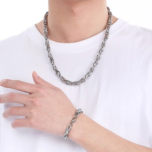 Close-up of polished silver stainless steel king chain necklace and bracelet on male model