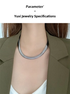 Detail shot of a sleek silver snake chain necklace showing fine metallic scale texture