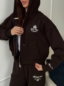 Détail de l'ensemble de survêtement marron foncé avec broderies et pantalon taille haute
