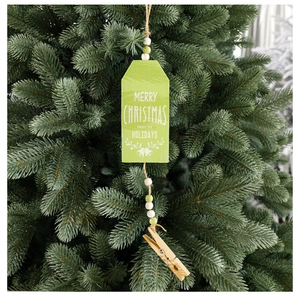 Close-up of wooden Merry Christmas tag with light green plaque and bead details