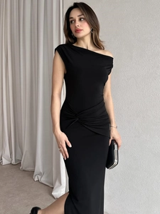 Detail of the elegant black one-shoulder midi dress featuring side slit and waist ruching