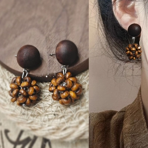 Detail of retro wooden earrings with geometric semicircle blocks and beaded ball design
