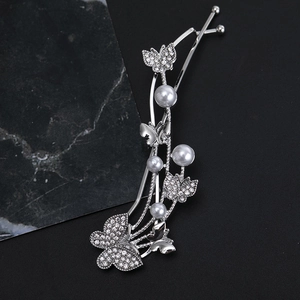 Silver butterfly hair clip with sparkling rhinestones and white pearls on black background