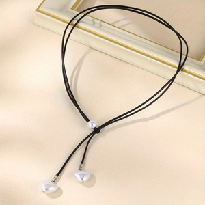 Collier en cordon ciré noir en Y avec pendentifs en perles en forme de cœur sur fond beige