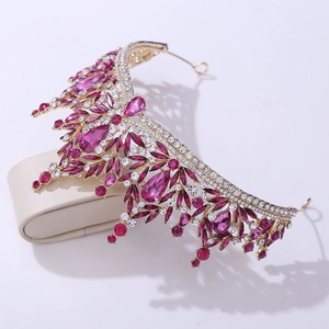 Detailed view of bridal crystal leaf crown with rose red gemstones on a gold base