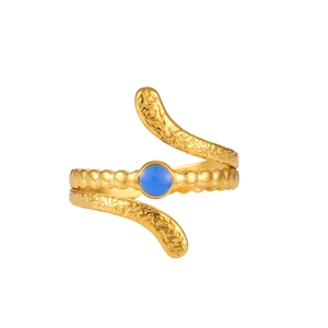 Detailed macro of a snake-shaped gold plated ring with blue gemstone and textured surface