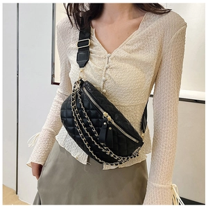 Close-up of black quilted fanny pack with stylish multi-layered gold metal chains