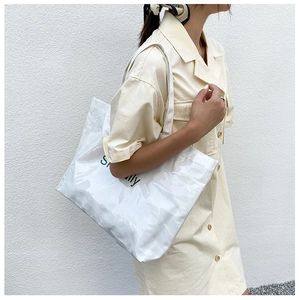White transparent PVC jelly tote bag shown with shoulder strap on a model