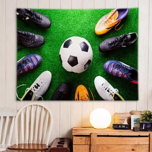 Detail of soccer themed wall tapestry featuring a football and colorful shoes on green grass