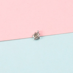 Polished silver star pendant base for DIY jewelry making on pastel background