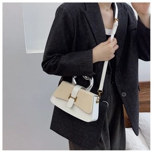Detail of white leather box bag featuring beige woven texture and unique metal handle