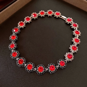 Detailed macro view of silver floral chain bracelet with red and black crystals
