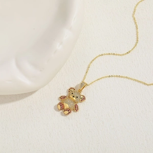 Close-up of a 14K gold plated bear pendant with sparkling zircons and purple gems