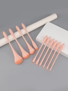 Close-up of 10-piece peach pink makeup brush set arranged on geometric blocks