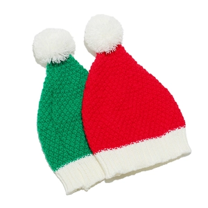 Coppia di cappelli di Babbo Natale in maglia rossi e verdi con soffici pompon bianchi invernali