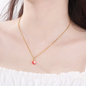 Close-up of a gold titanium necklace featuring a cute red and white fruit drop pendant