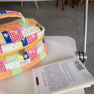 Gros plan détaillé d'une trousse à maquillage en patchwork matelassé aux motifs variés