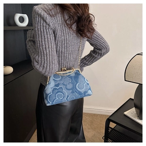 Detail of blue denim bag with auspicious cloud print, gold chain, and metal clasp