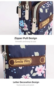 Close-up of durable metal zippers and lettered ribbon on navy floral shoulder bag